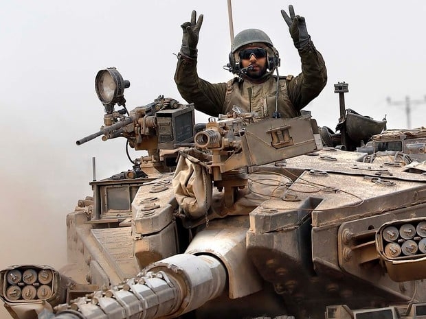 Um soldado israelense faz sinal de vitória a bordo de seu tanque perto da fronteira entre Israel e a Faixa de Gaza 