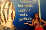 Drielle diante de mural com versículo: "Combati o bom combate, completei a carreira, guardei a fé". (Jornal Atual Rio)