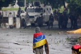 Manifestante de frente para as Forças Armadas em protesto contra Nicolás Maduro, na Venezuela. (Foto: Reuters/Carlos Garcia Rawlins)