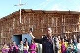 Em frente à igreja na África, cristãos seguram aparelho da Bíblia em áudio. (Foto: GHI)