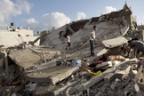 Palestinos tentam recuperar bens de um edifício destruído em um ataque israelense em Beit Lahya, norte da Faixa de Gaza