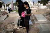 Mulher palestina e menina levam flores em um túmulo da família no feriado do fim do Ramadã (Eid al-Fitr) em Gaza. (