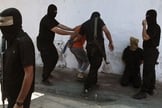 Militantes do Hamas cercam palestinos acusados de terem colaborado com Israel nesta sexta-feira(22); 18 foram mortos 