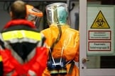 Agentes de saúde vestem roupas especiais para cuidar de pacientes com ebola