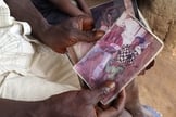 Em foto divulgada pela Unicef nesta quinta-feira (28), uma pessoa segura uma fotografia do menino Emile Ouamouno, ainda bebê: quando tinha 2 anos, o garoto foi a primeira vítima de ebola desta epidemia, e é conhecido como o 'paciente-zero'; ele, sua mãe, 