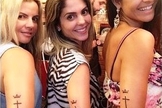 Esposa e enteada de Kleber Lucas fazem tatuagem com a marca de sua igreja no braço