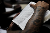 Jovem segurando a Bíblia durante culto em uma igreja evangélica, em São Paulo.  (Foto: Christian Tragni/ Folhapress)