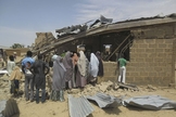 Pessoas são vistas ao redor de igreja que foi alvo de ataque suicida. (Foto: Adamu Adamu/AP)