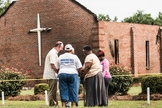 Grupo orando próximo às ruínas da igreja Mount Zion, na Carolina do Sul. (Sean Rayford/Getty Images)