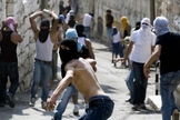 Jovens palestinos atiram pedras contra forças israelenses em Jerusalém (Foto: AFP)