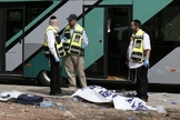 Forças de segurança israelenses conversam ao lado de corpo após ataque a tiros contra um ônibus próximo ao bairro palestino de Jabal Mukaber, em Jerusalém Oriental. (Foto: Thomas Coex/AFP)