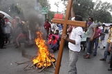 Membro da comunidade cristã paquistanesa segura uma cruz durante um protesto para condenar ataques contra igrejas. (Foto: Reuters/Mohsin Raza)
