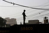 Soldado faz a segurança no terraço de prédio no Paquistão (Foto: Reuters)