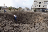 Homem sai de uma cratera causada pelo que, segundo ativistas, foi aberta pelo lançamento de bombas das forças leais ao presidente da Síria, Bashar Al-Assad. (Foto: Reuters)