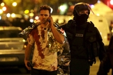Policial acompanha vítima do ataque à casa de shows 'Bataclan', em Paris. (Foto: Reuters)