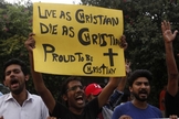 Manifestante paquistanês segura cartaz com as frases: "Viver como cristão! Morrer como cristão! Orgulho de ser cristão!". (Foto: Reuters)