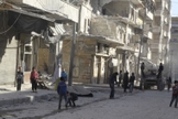 Moradores perto de edifícios danificados na vila de Kafr Hamra, no norte rural de Aleppo, Síria (27 de fevereiro de 2016). Foto: Reuters.