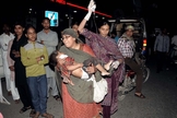Mulher segura criança que ficou ferida em atentado em parque de Lahore. (Foto: Arif Ali/AFP)