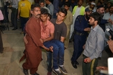 Vítima da explosão sendo socorrida depois que uma bomba explodiu em um parque público no Paquistão. (Foto: Arif Ali/AFP)