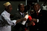 Diretor do Centro de Combate ao Terrorismo no Quênia acende vela em homenagem às vítimas do massacre em Garissa. (Imagem: Reuters)