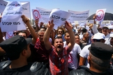 Manifestantes seguram placas e cartazes em protesto contra o Estado Islâmico no Iraque. (Foto: Reuters)