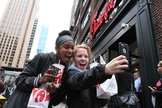 A jovem Jaimie Cranford (à direita) tira uma selfie com Mariah Reives (esquerda), exibindo sorrisos e seus lanches da rede lanchonetes fundadas por cristãos. (Foto: Tina Fineberg / AP Photo)