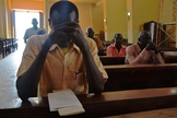Cristão sudanês ora dentro do templo de igreja. (Foto: La Stampa)
