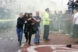 Imagem registrou momento em que Paul Sanderson (à direita) e outro homem ajudaram mãe e filho a fugir do tumulto gerado por torcedores antes de um jogo de futebol na Inglaterra. (Foto: Reuters)