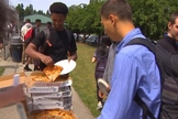 Estudante pega um pedaço de pizza grátis entregue pela igreja Bethany Community Church em Seattle, nos EUA. (Foto: Reprodução/Komo TV)