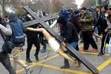 Ao final da marcha, da última quinta-feira, manifestantes mascarados entraram em uma igreja no centro de Santiago e destruíram a cruz 3 de metros de altura, com uma estátua de Jesus Cristo. (Foto: Reuters)
