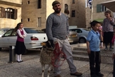Homem segura cordeiro separado para simulação de sacrifício de Páscoa. (Foto: Times Of Israel)