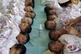 Bebês são cuidados por enfermeira na China. (Foto: South China Morning Post)