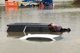 Pastor se arrisca sobre carros em meio à enchente que tem devastado Houston e outras regiões do Texas. (Foto: Facebook - Brian Roberson)