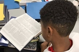 Garoto lendo a Bíblia. (Foto: Bible in The Schools)