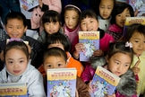 Crianças recebem literatura cristã infantil, distribuída por missionários, na China. (Foto: American Bible Society News)