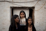 As filhas de Asia Bibi seguram uma imagem da mãe. (Foto: Reprodução).