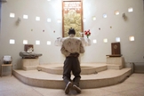Homem ora diante de altar em igreja, em Uganda. (Foto: Reuters)