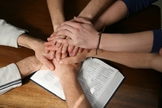 Mãos unidas sobre a Bíblia simbolizando a unidade da Igreja. (Foto: myocn.net)
