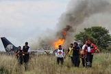 Socorristas carregam ferido em maca durante resgate após acidente com avião da Aeroméxico. (Foto: Red Cross Durango/AP)