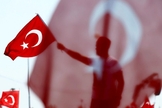 Homem segura bandeira da Turquia durante homenagem aos 'mártires da democracia'. (Foto: Reuters)