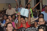 Cristãos participam de culto em Cuba, enquanto uma das fiéis expõe sua Bíblia. (Foto: United Bible Societies)