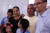 Ao lado dos filhos e do diretor da escola, casal se emocionou com nova casa. (Foto: Reprodução/TV Anhanguera)