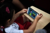 Criança assiste vídeo qualquer do Youtube em smartphone. (Foto: The Straits Times)