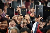 Cristãos Chineses mostram suas Bíblias em culto. (Foto: Bible Society - Australia)
