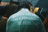 Em Porto Alegre, homem usa capa com versículo bíblico durante ato. (Foto: Matheus Bazzo)