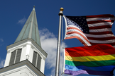 Bandeira do orgulho gay junto com a bandeira dos EUA em frente à Igreja Metodista Unida de Asbury, nos EUA. (Foto: AP)