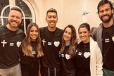 Em seu batismo, Roberto Firmino contou com a presença de sua esposa, Larissa Pereira, do parceiro de time Alisson Becker e da cantora Gabriela Rocha. (Foto: Instagram)