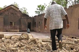 Cristão caminha por escombros de igreja incendiada na Nigéria. (Foto: Portas Abertas)