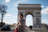 Mulher usa máscara de proteção perto do Arco do Triunfo, em Paris, na França. (Foto: Gonzalo Fuentes/Reuters)
