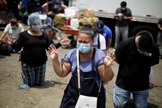 Fornecedores do maior centro de suprimentos de frutas e legumes de San Salvador em momento de oração. (Foto: EFE/Rodrigo Sura)